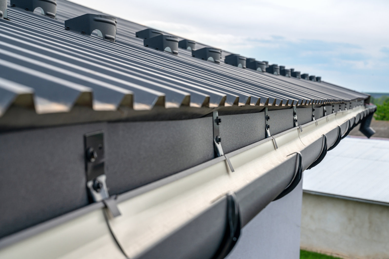 New gutter and brackets installed along the roofline of a house