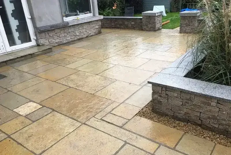 Sandstone patio with stone-clad raised beds and granite copings in Dublin
