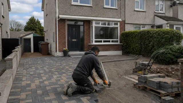 Paver laying grey and buff cobblelock blocks on a Dublin driveway